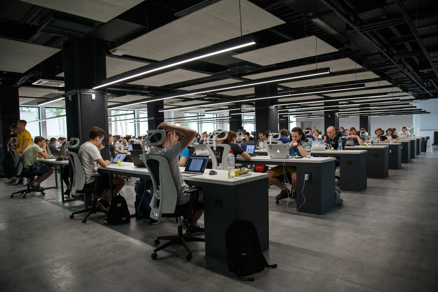 A large open-plan office with rows of people at laptops