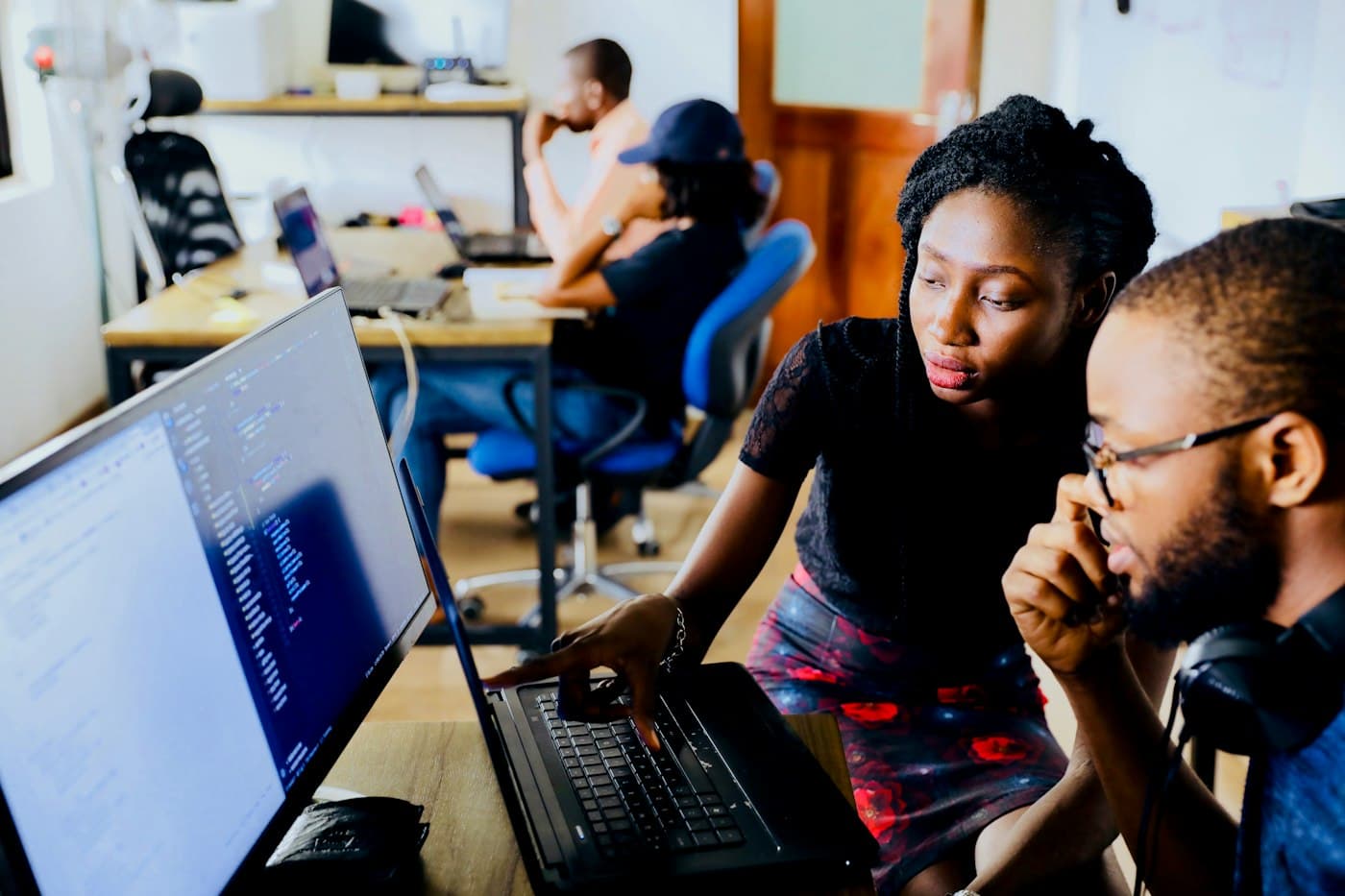 Colleagues reviewing code together on a laptop