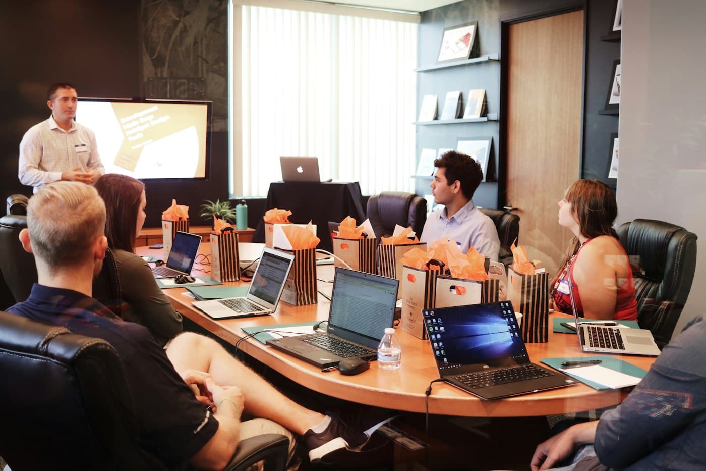 A presenter addressing a team around a boardroom table